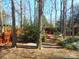 Secluded backyard with mature trees, stone-lined walkway, and a cozy seating area in the distance at 9331 Hanworth Trace Dr, Charlotte, NC 28277