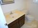 Bathroom with dark vanity, cream sink, and toilet at 9331 Hanworth Trace Dr, Charlotte, NC 28277