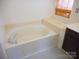 Bright bathroom featuring a soaking tub with tile surround and neutral walls, offering a relaxing retreat at 9331 Hanworth Trace Dr, Charlotte, NC 28277