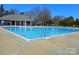 Large community pool with clear blue water and a clubhouse in the background, perfect for summer relaxation at 9331 Hanworth Trace Dr, Charlotte, NC 28277