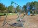 Community playground featuring swings and climbing equipment with mature trees, perfect for outdoor activities at 9331 Hanworth Trace Dr, Charlotte, NC 28277