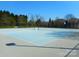 Well-maintained tennis court with a vibrant blue surface and surrounding trees, ideal for recreational activities at 9331 Hanworth Trace Dr, Charlotte, NC 28277