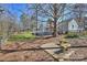 A backyard with a wooden deck, playset slide, small patio, and a surrounding wooden fence at 9505 Kent Village Dr, Charlotte, NC 28269