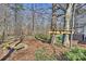 Landscaped backyard with play area, including a tree platform, deck slide, and wooden bench at 9505 Kent Village Dr, Charlotte, NC 28269