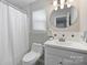 Clean bathroom featuring white fixtures and shower with decorative detail at 9505 Kent Village Dr, Charlotte, NC 28269
