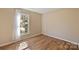 Bright bedroom featuring hardwood floors and a window overlooking a lush outdoor view at 9505 Kent Village Dr, Charlotte, NC 28269