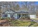Charming single story home with light siding, complemented by a well-manicured lawn and mature trees at 9505 Kent Village Dr, Charlotte, NC 28269
