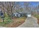 Charming single story home with light siding, complemented by a well-manicured lawn and mature trees at 9505 Kent Village Dr, Charlotte, NC 28269