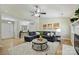 Bright living room with vaulted ceilings, a ceiling fan, a gray sofa, artwork, and a fireplace at 9505 Kent Village Dr, Charlotte, NC 28269