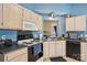 Kitchen featuring white cabinets, dark countertops, and a view into another room at 14429 Planters Knob Ln, Charlotte, NC 28273