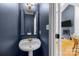 Stylish powder room with a pedestal sink and dark blue walls at 1509 Orange Hill Ct, Gastonia, NC 28056