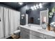 Dark bathroom with double vanity, mirror, and white waffle-weave shower curtain at 1509 Orange Hill Ct, Gastonia, NC 28056