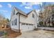 View of the home's garage, driveway, and manicured lawn with white picket fence at 1509 Orange Hill Ct, Gastonia, NC 28056