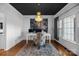 Office features a modern chandelier, white wainscoting, hardwood floors, and a bright picture window at 1509 Orange Hill Ct, Gastonia, NC 28056