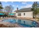 In-ground pool with a brick border, with a cozy deck featuring a pergola, and patio furniture at 1509 Orange Hill Ct, Gastonia, NC 28056