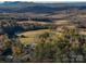 Breathtaking aerial shot reveals a sprawling estate nestled amid lush forests and rolling farmlands with mountain views at 153 Badenyon Pl, Union Grove, NC 28689
