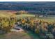 Aerial view of a wooded property, with a home, outbuilding, and long driveway amid colorful fall foliage at 153 Badenyon Pl, Union Grove, NC 28689