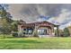 Beautiful backyard with a covered patio, outdoor fireplace, and lush landscaping, ideal for relaxation and outdoor gatherings at 153 Badenyon Pl, Union Grove, NC 28689