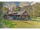 Charming wooded home with a metal roof, mature landscaping, and an attached covered parking area at 153 Badenyon Pl, Union Grove, NC 28689