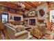 Cozy living room with a stone fireplace, wood beams, and comfortable seating, creating a welcoming atmosphere at 153 Badenyon Pl, Union Grove, NC 28689