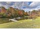 Picturesque pond with a fountain, dock, and colorful fall foliage creates a serene and inviting outdoor space at 153 Badenyon Pl, Union Grove, NC 28689