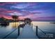 Picturesque waterfront view featuring a private dock with a boat lift and gazebo, capturing a serene sunset at 16439 Jetton Rd, Cornelius, NC 28031