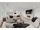 Spacious living room with a large sectional sofa, stone fireplace, and a fully stocked bar in the background at 16439 Jetton Rd, Cornelius, NC 28031