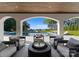 Covered outdoor living space with a view of the pool, lush lawn, and lake in the distance at 16439 Jetton Rd, Cornelius, NC 28031