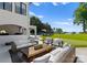 An outdoor space offers comfortable seating, a wooden coffee table, and a lush lawn leading to the waterfront at 16439 Jetton Rd, Cornelius, NC 28031