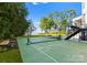A private backyard tennis court for recreation and exercise, set against a backdrop of lush greenery at 16439 Jetton Rd, Cornelius, NC 28031