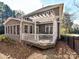 Exterior home view with sunroom, white pergola, deck, and fenced yard at 18322 Indian Oaks Ln, Davidson, NC 28036