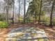 Backyard with stone tile area, trees and black metal fence at 18322 Indian Oaks Ln, Davidson, NC 28036