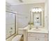 Bright bathroom featuring white cabinetry, shower-tub and framed mirror at 18322 Indian Oaks Ln, Davidson, NC 28036