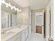 Bright bathroom with marble floors, double vanities, and modern light fixtures at 18322 Indian Oaks Ln, Davidson, NC 28036
