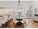 Dining area featuring a modern chandelier, bay window, hardwood floors, and adjoins a kitchen and living room at 18322 Indian Oaks Ln, Davidson, NC 28036