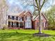 Beautiful two story brick home with green lawn and mature trees on a sunny day at 18322 Indian Oaks Ln, Davidson, NC 28036