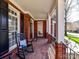 Charming front porch with brick flooring, rocking chairs and white columns at 18322 Indian Oaks Ln, Davidson, NC 28036