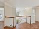 Open landing with wood floors, decorative molding and a view of the foyer below at 18322 Indian Oaks Ln, Davidson, NC 28036