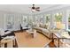 Bright living room with a curved sofa, lots of windows, neutral colors and an adjacent screened in porch at 18322 Indian Oaks Ln, Davidson, NC 28036