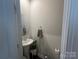 Well-lit half bathroom with sleek pedestal sink, round mirror, and modern towel ring at 202 J.P. Dr # 183, Albemarle, NC 28001