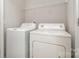 Laundry room featuring side-by-side washer and dryer units and a storage shelf at 2026 Talbert Ct, Charlotte, NC 28214