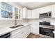 Bright kitchen features white cabinets, stainless steel appliances, an island, and wood-look floors at 2206 Hillcrest Ave, Albemarle, NC 28001