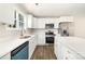 Bright kitchen features white cabinets, stainless steel appliances, an island, and wood-look floors at 2206 Hillcrest Ave, Albemarle, NC 28001