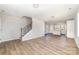 Open-concept living room with wood floors, staircase, and connection to kitchen at 2206 Hillcrest Ave, Albemarle, NC 28001