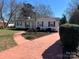 Well kept home featuring a brick walkway, complemented by lush landscaping and mature trees at 3240 Sunset Dr, Charlotte, NC 28209