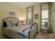 Bedroom featuring a black iron bed, dual windows, striped curtains and neutral carpet at 4006 Hickory View Dr, Fort Mill, SC 29707