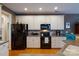 Efficient kitchen with white cabinetry, black appliances, and hardwood floors for an inviting space at 4006 Hickory View Dr, Fort Mill, SC 29707