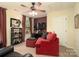 Living room featuring a ceiling fan, a red couch, carpet and a large window at 4006 Hickory View Dr, Fort Mill, SC 29707