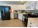 Modern kitchen featuring white cabinets, stainless appliances, and wood-look flooring at 4586 Antelope Ln, Charlotte, NC 28269