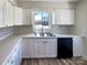 Modern kitchen featuring white cabinets, stainless steel sink, and laminate countertops under natural light at 4808 Cedar Ct, Gastonia, NC 28056